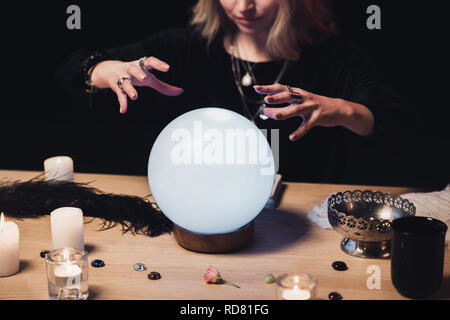 Portrait de femme tenant les mains au-dessus ésotérique crystal ball isolated on black Banque D'Images
