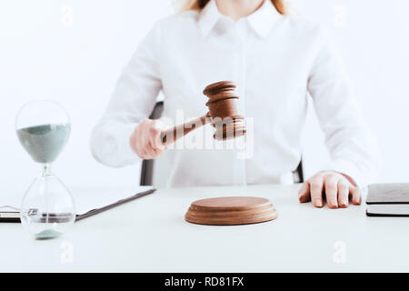 Portrait de femme juge avec marteau en main près de sable d'exécution avec hourglass isolated on white Banque D'Images