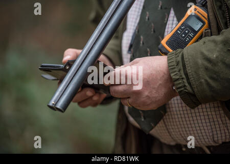 Homme avec fusil de chasse et le téléphone mobile Banque D'Images