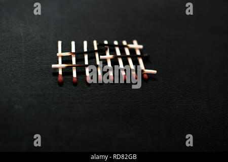 Photo de brûlé et allumettes matchstick red head. Isolé sur le fond noir. Banque D'Images