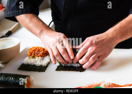 Chef making rouleaux de sushi au bar close up Banque D'Images