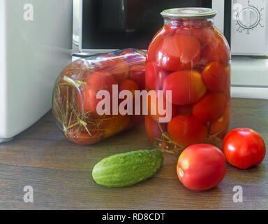 Accueil préservation : grands pots en verre avec des tomates marinées mûr rouge, couvercle métallique scellée. Banque D'Images