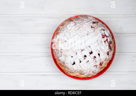 Délicieux petit cherry Pie saupoudrés de sucre glace sur la plaque sur la vieille table en bois blanc. Tarte aux cerises, série de décisions Banque D'Images