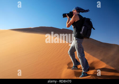 Woman photographing on Elim Dune Namib-Naukluft National Park, Namibie, Afrique Banque D'Images