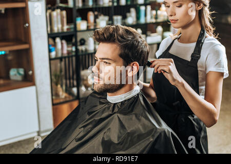 Cropped shot of coiffure peigner les cheveux de beau jeune homme en instituts de beauté Banque D'Images