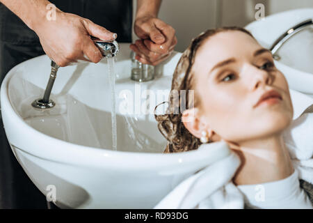 Cropped shot de coiffure et de l'eau contrôle de laver les cheveux de jeune femme en instituts de beauté Banque D'Images