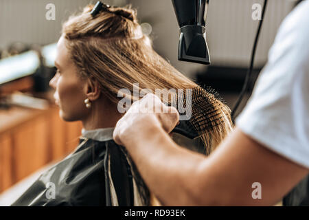 Cropped shot de coiffure cheveux séchage pour jolie jeune fille en instituts de beauté Banque D'Images