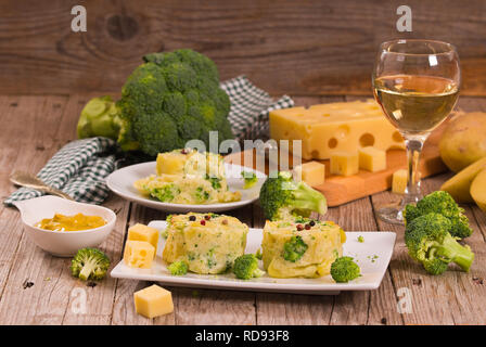 Les gratins de pommes de terre avec des fleurons de brocoli.