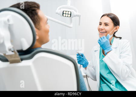 Female dentist holding drill near patient Banque D'Images