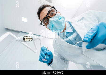 African American dentiste dans les verres avec des instruments dans les mains Banque D'Images