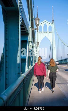 Deux jeunes filles avec un bon ajustement et de longs cheveux de marcher le long de la promenade de l'arches gothiques du St Johns pont sur la rivière Willamette Banque D'Images