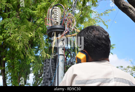 Technicien est de brancher un câble réseau à la prise de ligne. Banque D'Images