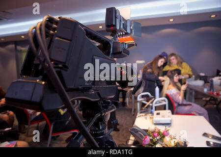 Caméraman sur appareil photo professionnel en tenant l'intervieweur film interview celebrity news qui l'extérieur . Cosmétique maquillage à la maison. L'accent sur t Banque D'Images