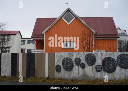 Orange house à Reykjavik, Islande. Avec l'art de rue sur sa clôture. Banque D'Images