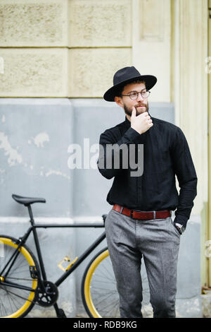 Jeune homme hipster équitation vélo pignon fixe on city street Banque D'Images