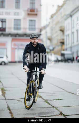 Jeune homme barbu avec riding bicycle on city street Banque D'Images