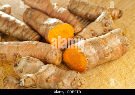 Curcuma curcuma frais avec des tranches de racine sur sol en bois Banque D'Images