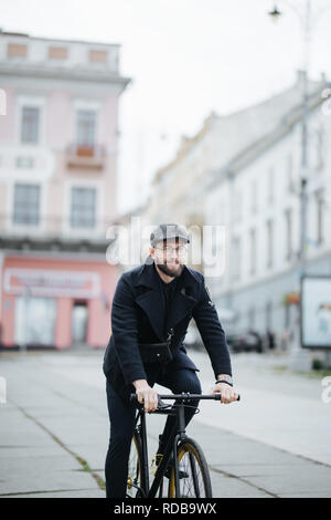 Jeune homme barbu avec riding bicycle on city street Banque D'Images