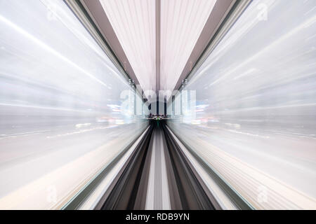 Flou de mouvement du train se déplaçant à l'intérieur de tunnel avec la lumière du jour à Tokyo, Japon. Banque D'Images