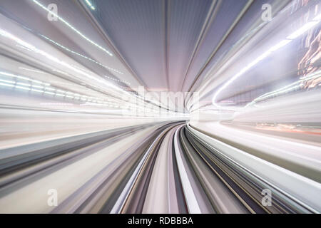 Flou de mouvement du train se déplaçant à l'intérieur de tunnel avec la lumière du jour à Tokyo, Japon. Banque D'Images