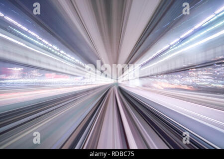 Flou de mouvement du train se déplaçant à l'intérieur de tunnel avec la lumière du jour à Tokyo, Japon. Banque D'Images