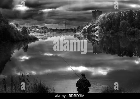 Pêcheur solitaire sur une large rivière. Journée ensoleillée met en lumière des réflexions sur l'eau calme en douceur. Bright sun light sky tree forest. Fisher avec la tige sur la rive. Russie Moscow salon nature paysage Banque D'Images