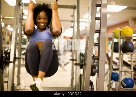 Smiling young woman working out dans la salle de sport. Banque D'Images