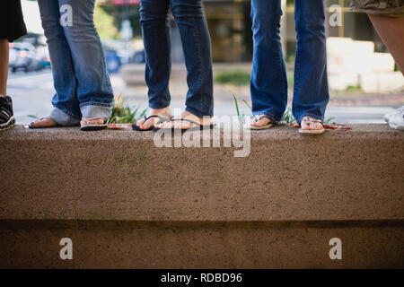 Les personnes portant des jeans debout sur Vire Banque D'Images