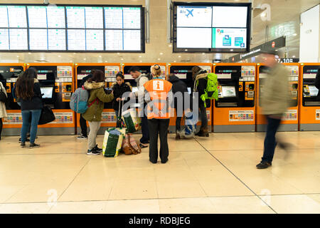 Renfe de l'hôte d'aider les voyageurs à acheter des billets dans les distributeurs automatiques de la gare Sants de Barcelone, de l'information rodalies Catalogne, Espagne Banque D'Images