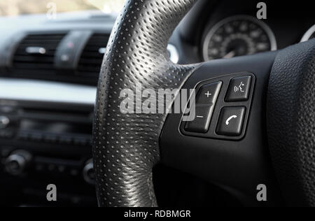 Téléphone mobile sur les boutons du volant de voiture Banque D'Images