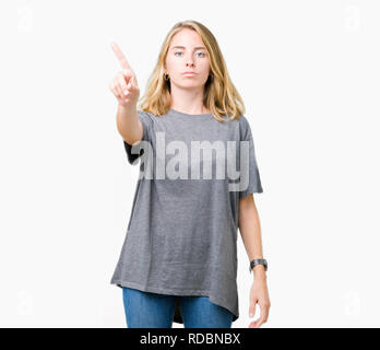 Belle jeune femme portant des T-shirt oversize sur fond isolé avec le doigt pointant vers le haut et l'expression de colère Banque D'Images