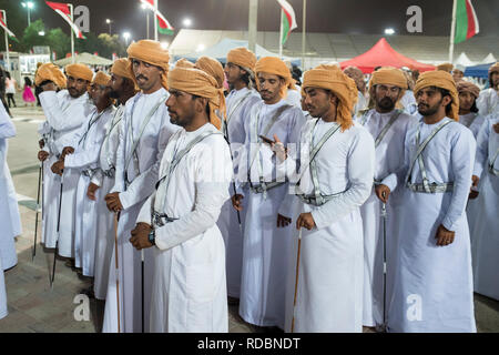 Des hommes en robe blanche - dishdash omanais et turban - comme ils se préparent à effectuer une danse traditionnelle a l'Ile Maurice Tourisme Festival à Oman. Banque D'Images