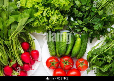 Ensemble de différents ingrédients pour la salade : tomates, concombre, radis, roquette, laitue, vue d'en haut. Concept d'aliments sains. Banque D'Images