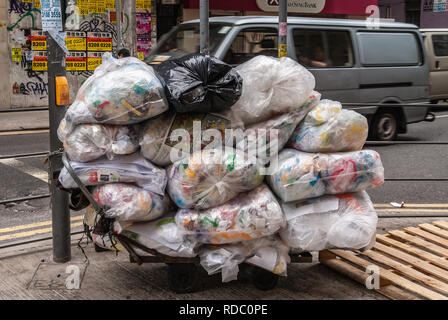 Hong Kong, Chine - 13 mai 2010 : Kowloon. Dolly surchargés avec de grands sacs en plastique transparent plein d'ordures le long de la rue Nathan Road. Par voiture. Banque D'Images