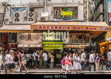 Hong Kong, Chine - 13 mai 2010 : Section continentale de Kowloon. Ligne de petites boutiques de restauration rapide pour les piétons sur Nathan Road. School in whit Banque D'Images