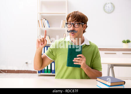 Étudiant avec fake moustache reading book Banque D'Images