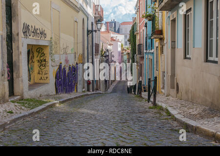 Lisbonne, Portugal - 20 octobre 2018 : Cobblestone street ville liquidation de colline dans quartier résidentiel avec des murs couverts de graffitis à Lisbonne, por Banque D'Images