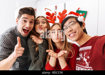 Groupe de personnes multiethnique gaie célébrant le Nouvel An et en tenant ensemble photo selfies Banque D'Images