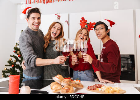 Groupe de gens heureux nouvel an fête multiethnique et intérieur clinking glasses avec vin Banque D'Images