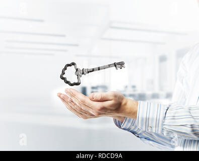 Close up of businessman hands holding ancienne clé comme symbo pour le succès. Technique mixte Banque D'Images