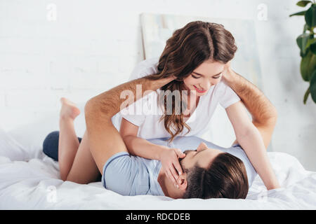 Focus sélectif de hot couple aimant sourire doux et embrassant au lit Banque D'Images