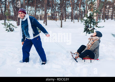 Man carrying his daughter sur traîneau. Family in winter park. Père et fille de passer du temps ensemble Banque D'Images
