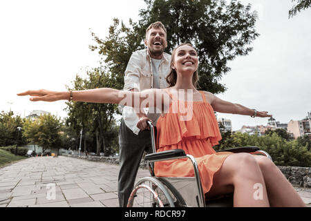 Beau jeune homme aidant jolie fille handicapée Banque D'Images