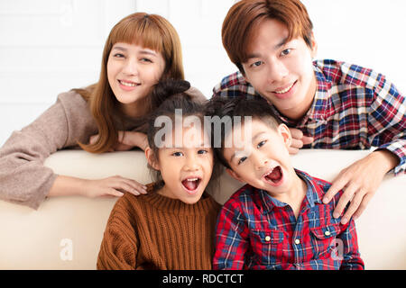 Happy asian family sitting on sofa at home Banque D'Images