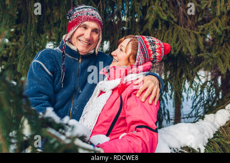 Couple hugging and laughing in winter forest. Heureux l'homme et de la femme la marche à l'extérieur le jour de la Saint-Valentin. Banque D'Images