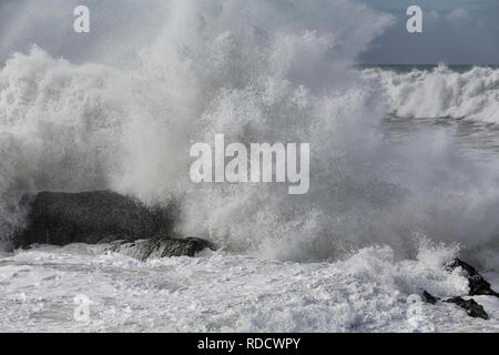 Grand bruit des vagues se briser contre les rochers de la plage. Banque D'Images