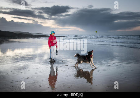 Garrettstown, Cork, Irlande. 18 janvier, 2019. Ruth Herman de Kinsale jouant à la balle avec son chien Broccie avant le lever du soleil à Garrettstown, co Cork, Irlande. Crédit : David Creedon/Alamy Live News Banque D'Images