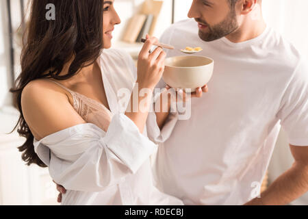 Femme Homme d'alimentation avec des céréales au petit-déjeuner, le matin Banque D'Images