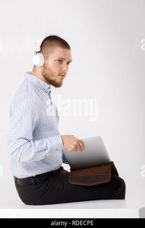 Businessman in headphones met dans le couvercle pour ordinateur portable Banque D'Images