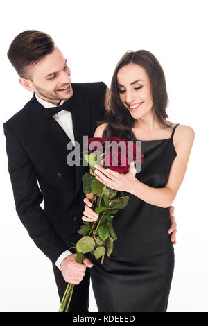 Beautiful couple posant avec fleurs rose rouge le Jour de Valentines, isolated on white Banque D'Images